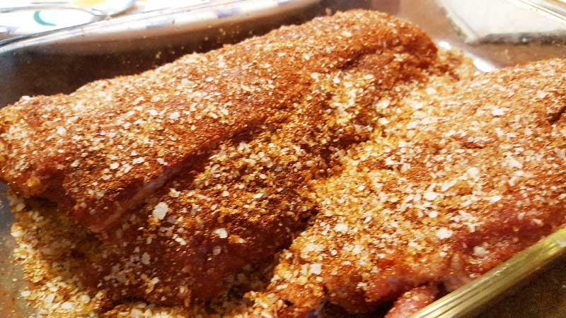 Baby back ribs with a liberal amount of rub on it.