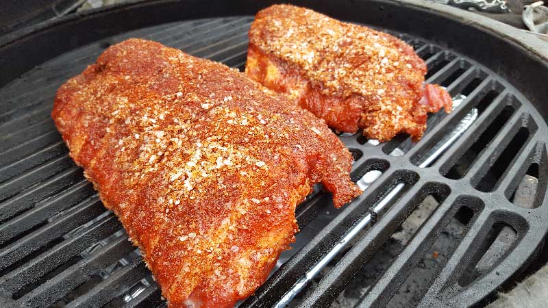 Rubbed baby back ribs meat side up on the Big Green Egg.
