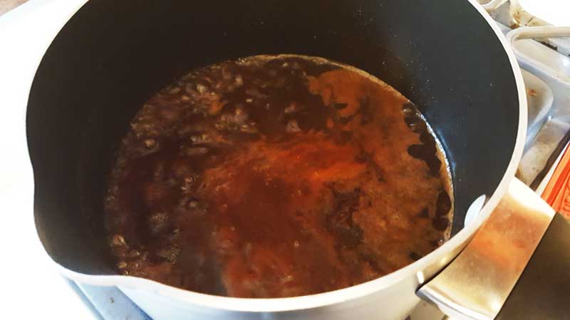 Dr. Pepper sauce boiling in a pot.