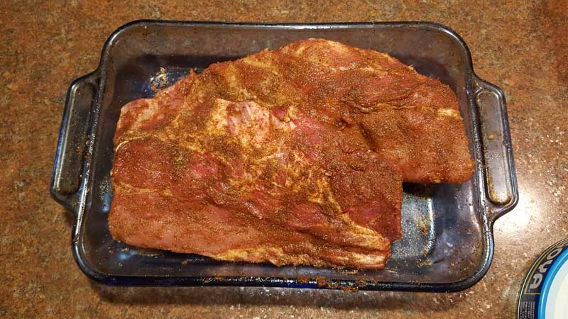 Baby back ribs covered in a rub.