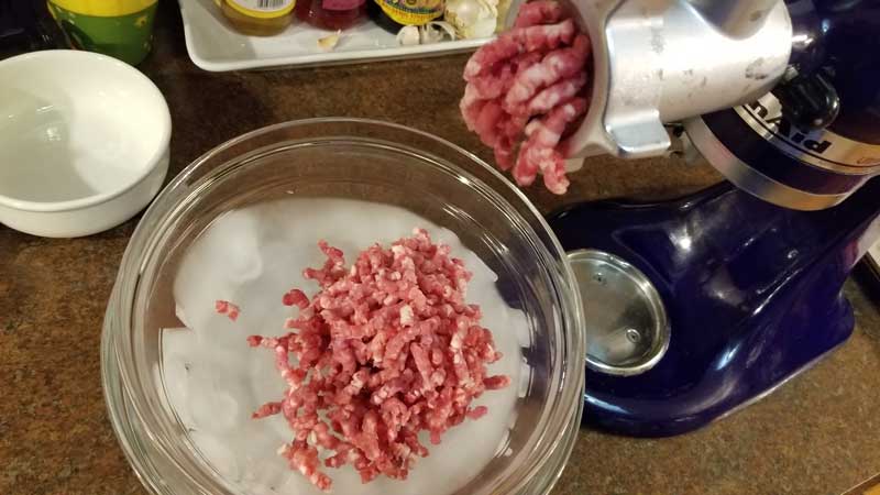 Meat coming out of a grinder.