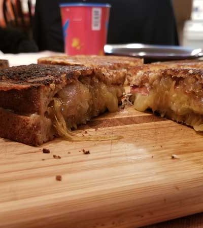 Grilled cheese sliced in half on a cutting board.
