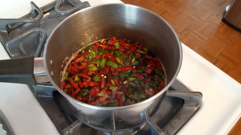 Cherry cola with red and green jalapenos in a pot.