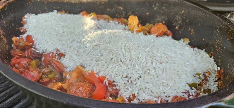 Uncooked rice added to the Dutch oven.