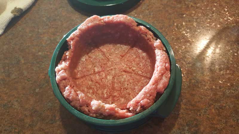 Meat cup in a burger press.