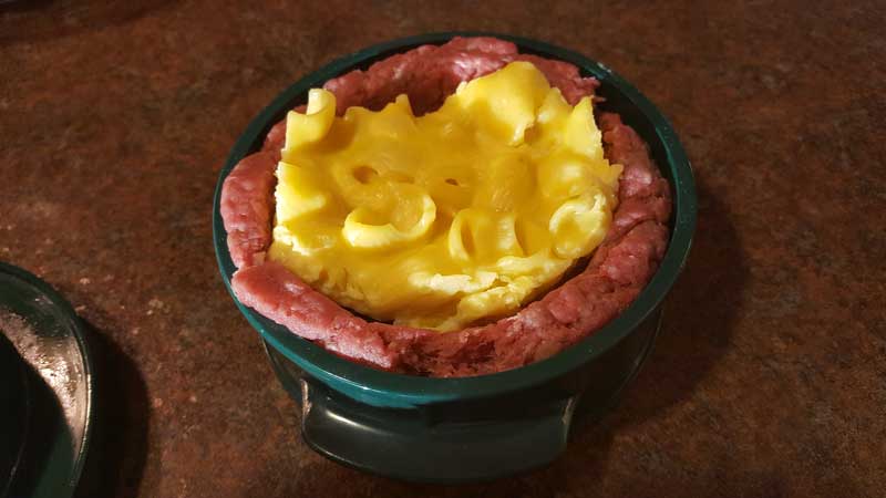 Mac and cheese round inside a burger cavity.