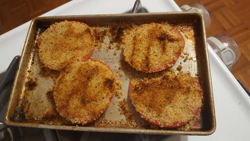 Tomato slices with toasted breadcrumbs on top.