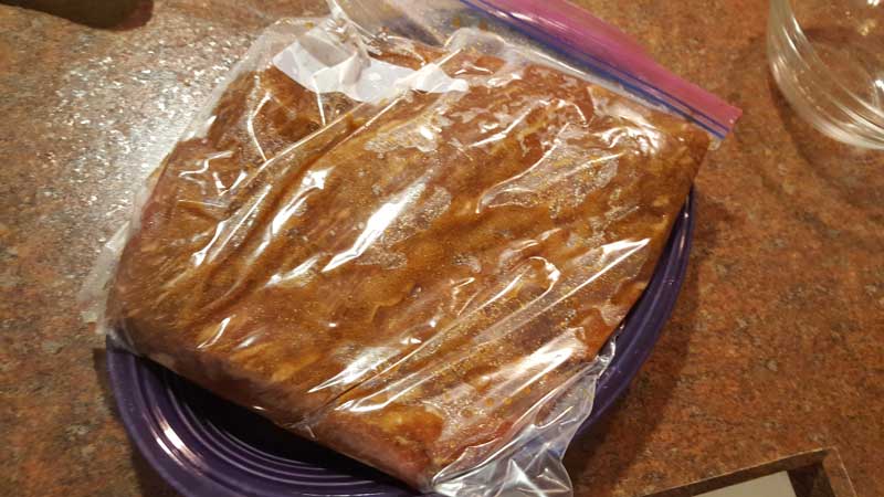 Brisket covered in cure in a bag.