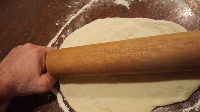 Pizza dough being rolled out.