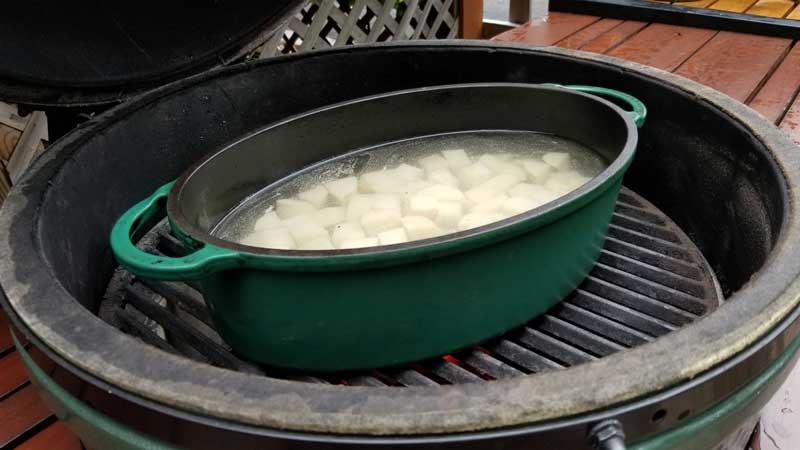 Dutch oven with potatoes in water on Big Green Egg.