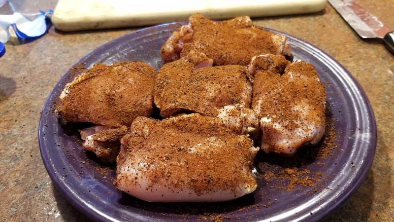 Chicken thighs covered in spice.