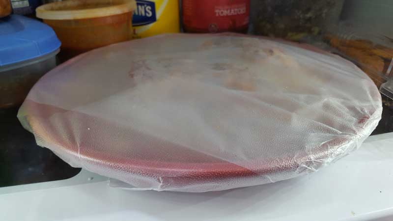 Plate covered in plastic wrap.