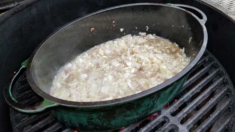 Onions and garlic sauteing in a Dutch oven.