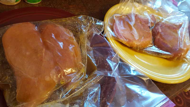 Pork and chicken marinating in separate bags.
