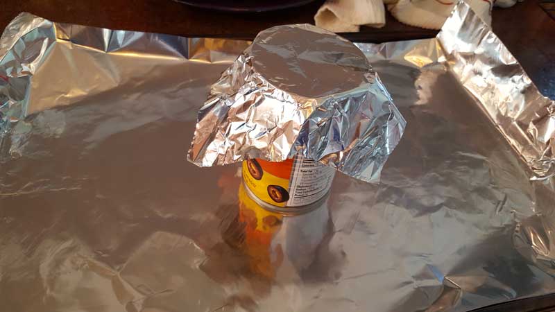Can covered in aluminum foil on top of a foil lined baking sheet.