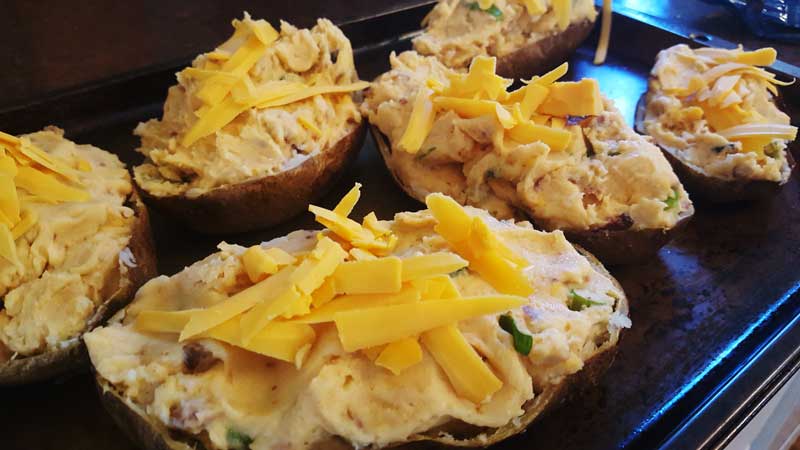 Potato skins stuffed with mash potato mixture topped with cheddar cheese.