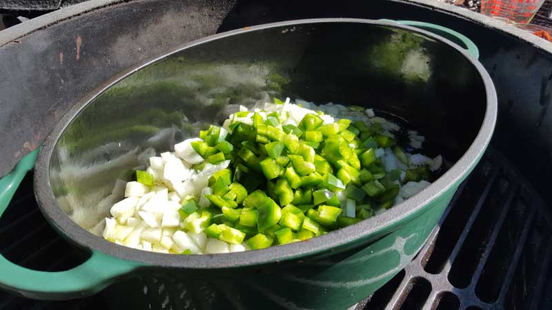 Chopped green pepper and onion in a dutch oven.
